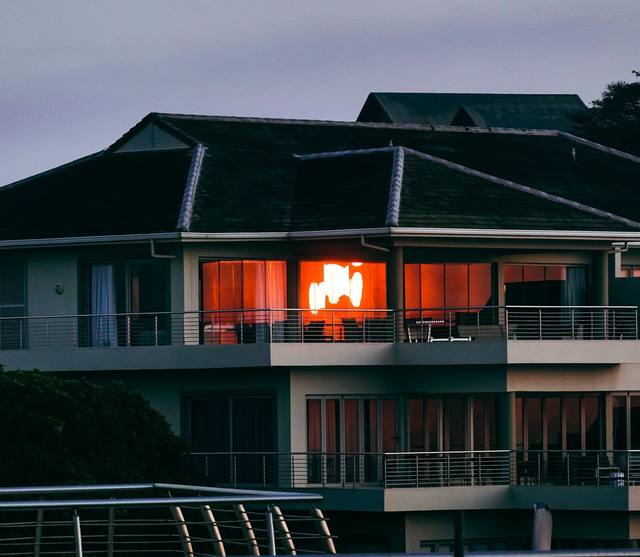 A family home with its lights on at dusk